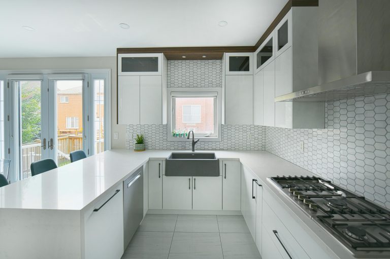 Bright and spacious modern kitchen featuring a large island, farmhouse sink, and sleek cabinetry.
